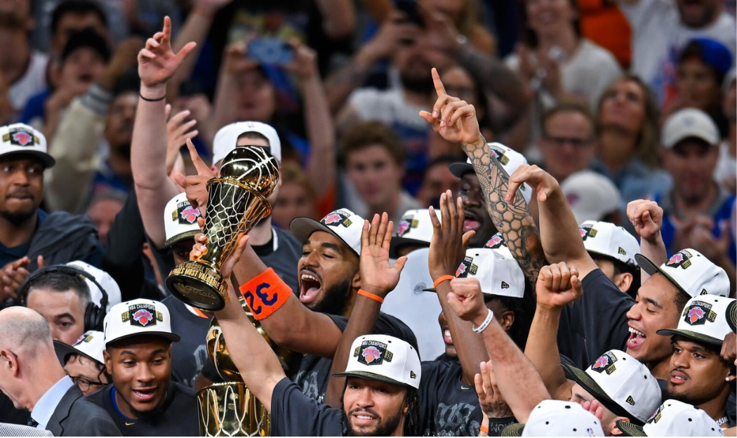 New York Knicks players celebrating with NBA Finals trophy at center court
